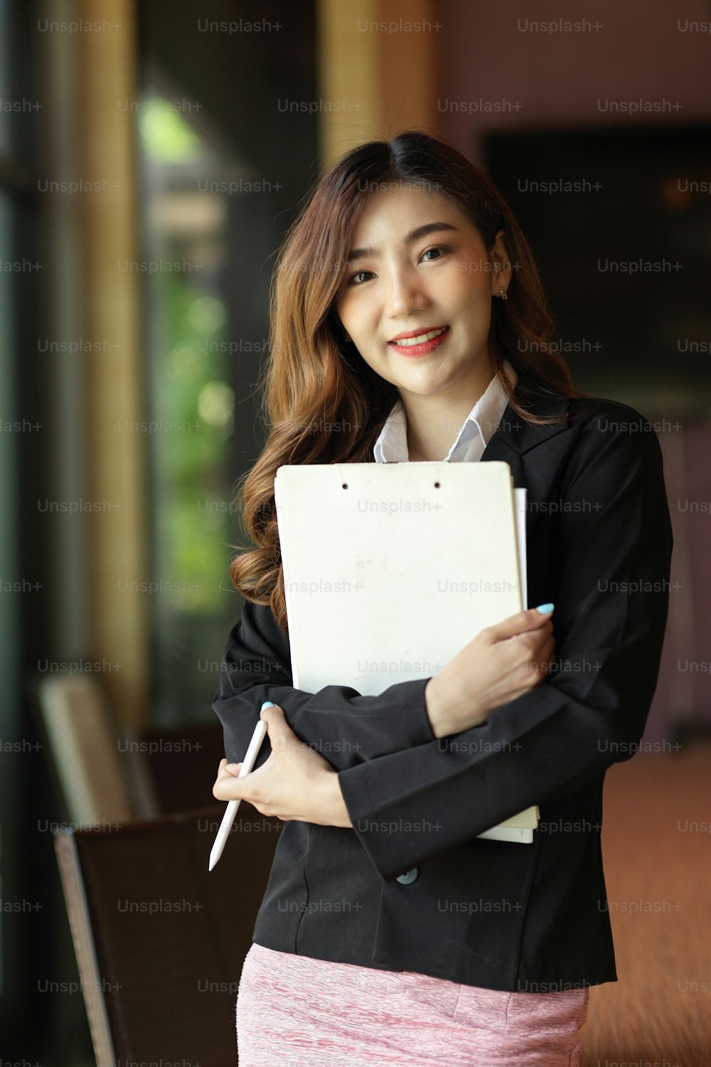 Photo of attractive asian young businesswoman smiling and holding clipboard organiser work at board room