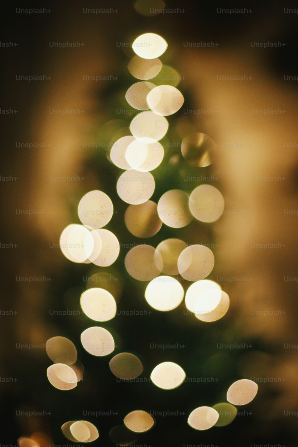 Weihnachtshintergrund. Weihnachtsbaumbeleuchtung defokussiert im abendlichen Festraum. Leuchtendes Beleuchtungsbokeh. Stimmungsvoller Heiligabend. Frohe Weihnachten und frohe Feiertage