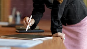 Cropped shot, close up, female company worker lean on office desk signing business contract on digital tablet, wooden desk