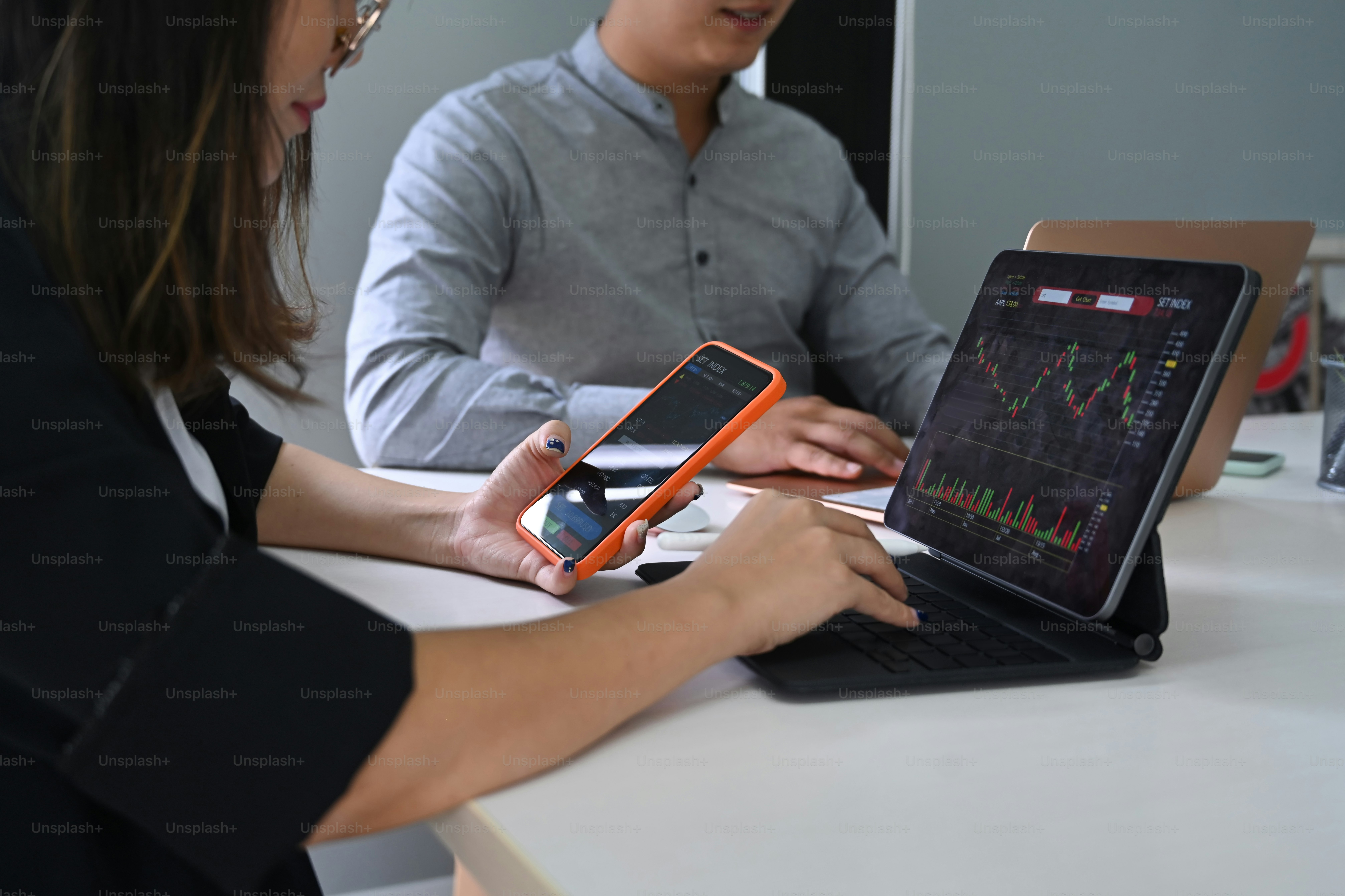 Two business colleagues analyzing graph on computer tablet together.