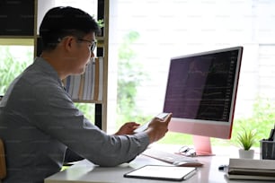 Businessman analyzing statistical data on screen of computer at office.