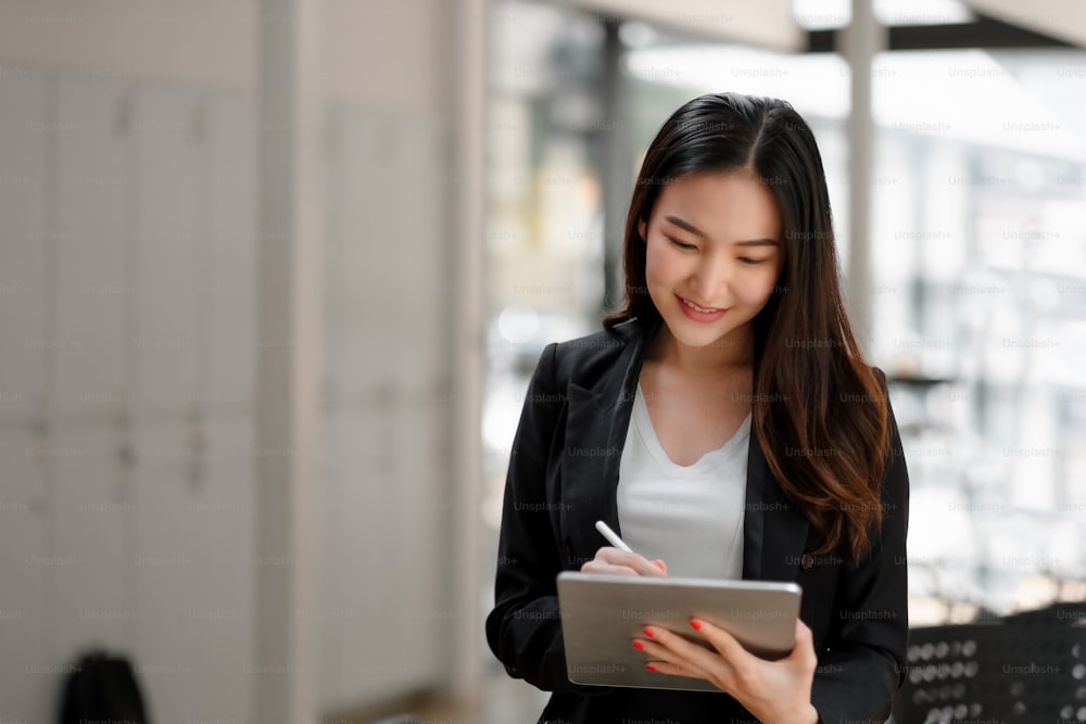 portrait of asian business woman using digital tablet in company meeting room.