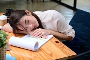 Asian business woman sleeping at her office desk.