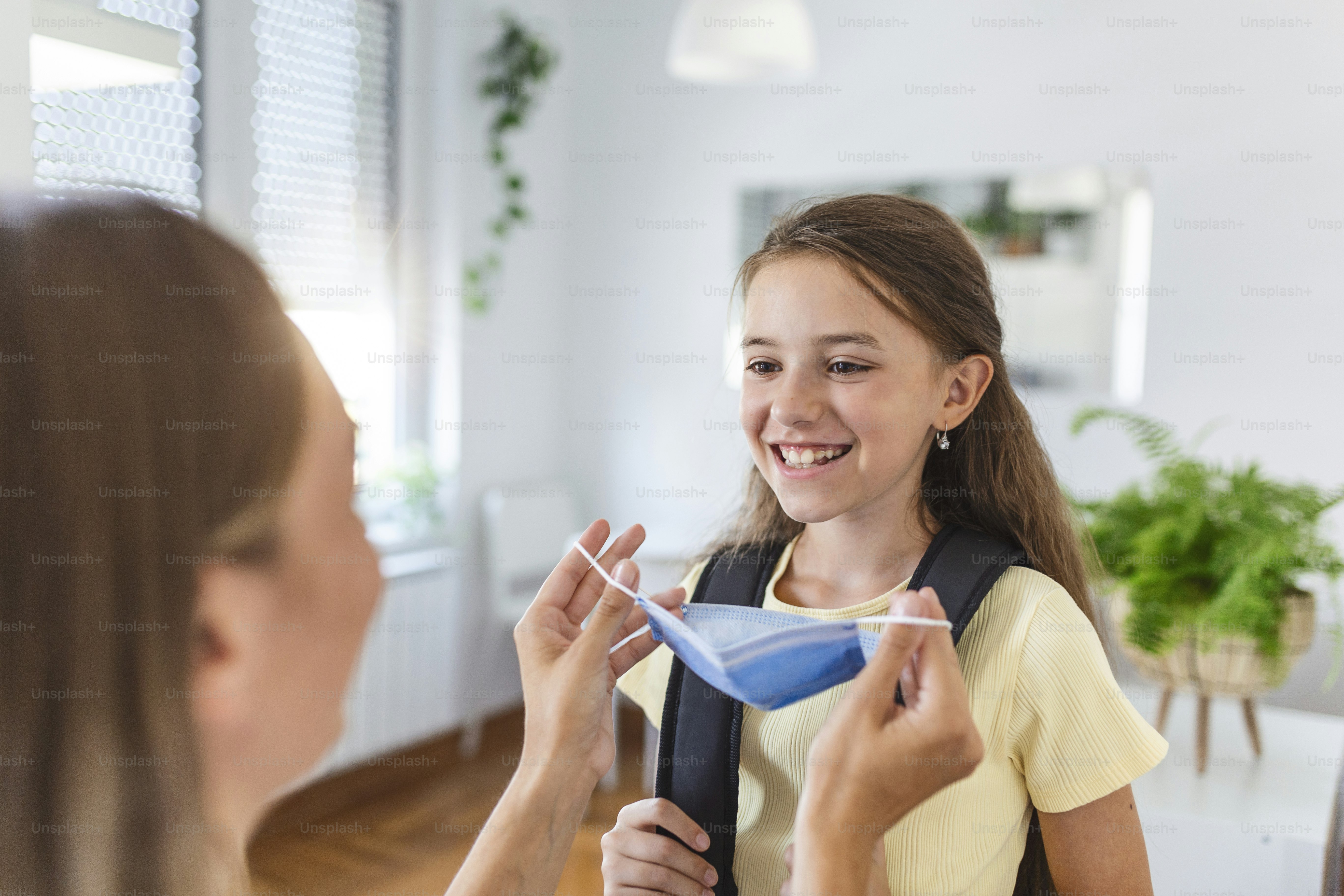 Young mother help her daughter wearing medical mask to prepare go to school. Avoiding Covid-19 or coronavirus outbreak. Back to school
