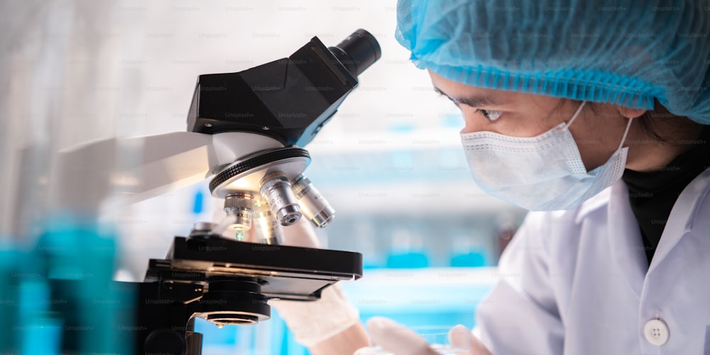 scientist looking through scientific microscope lense in laboratory, scientist doing research in term of medicine biotechnology biology or chemistry, doctor analyzing work in medical microbiology lab