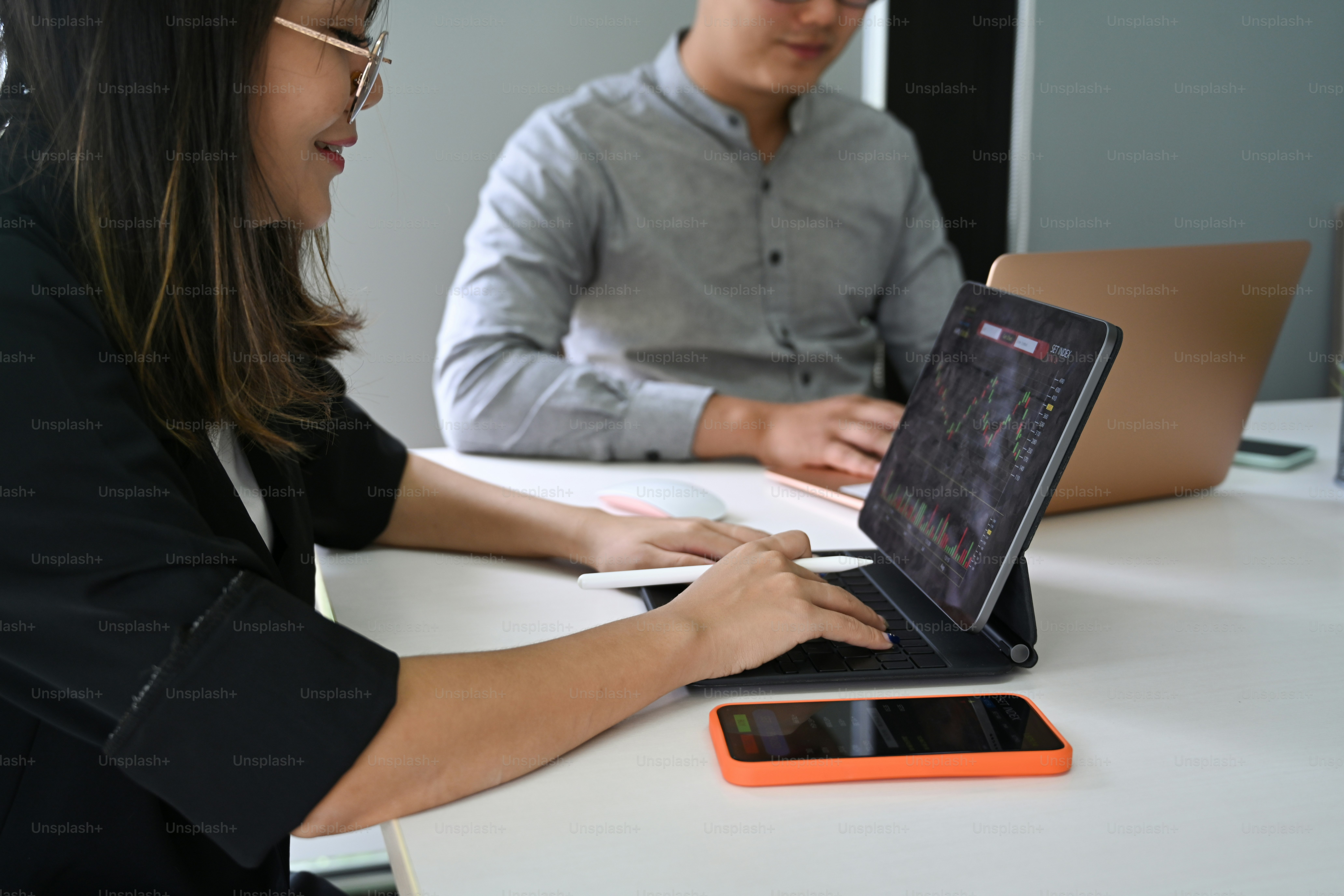 Business people analyzing graph of stock market with computer tablet.