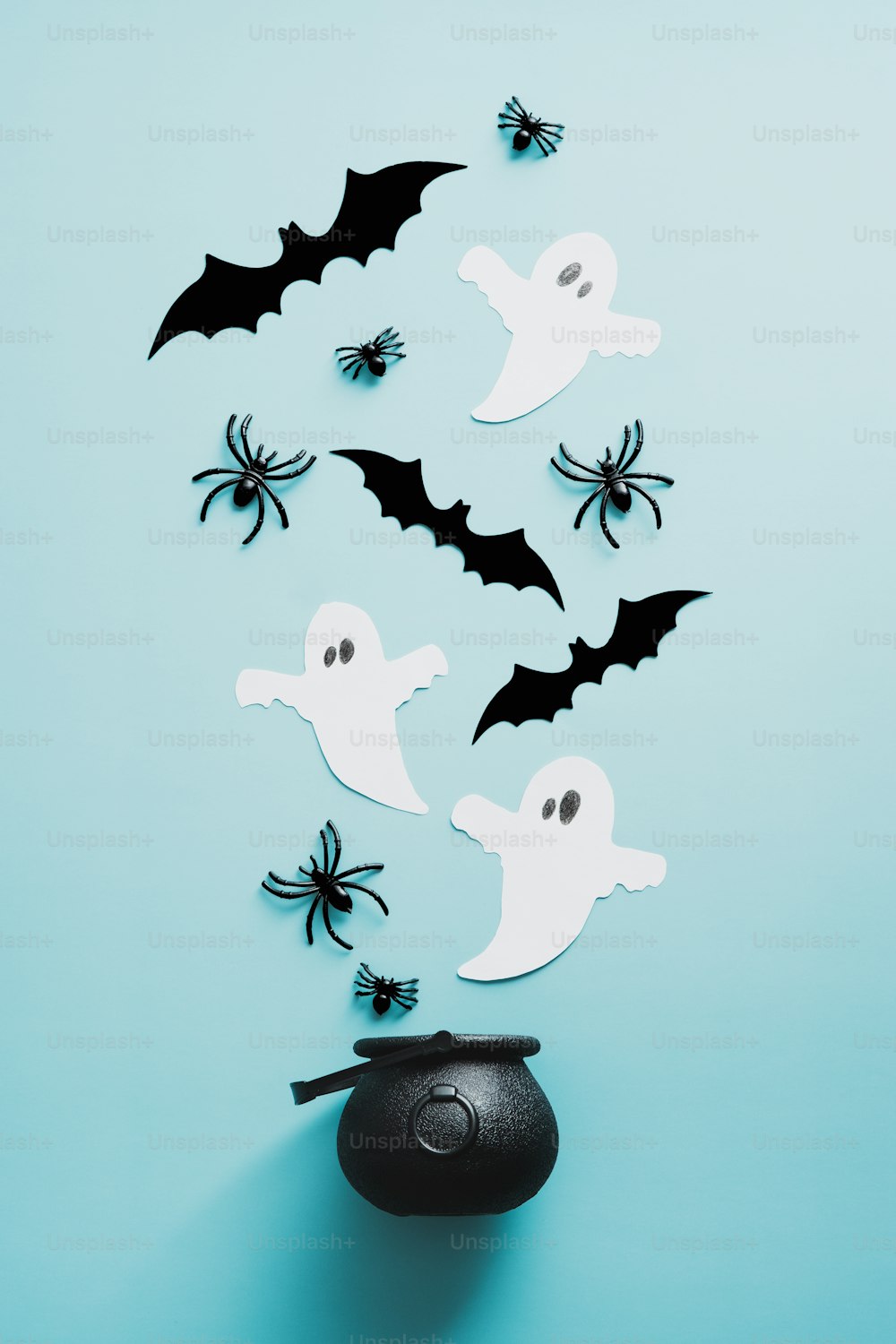 Halloween witchcraft potion with spiders, ghosts, bats on blue background. Flat lay, top view, overhead.