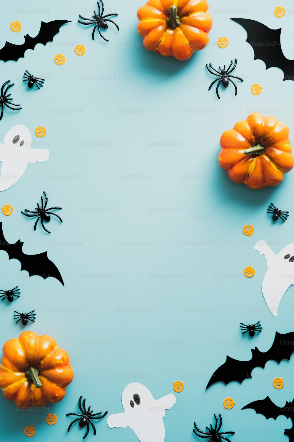 Feliz conceito de feriado de halloween. Decorações de Halloween, morcegos, fantasmas, aranhas, abóboras no fundo azul. Maquete de pôster da festa de Halloween com espaço de cópia. Flat lay, vista superior, sobrecarga.