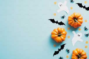 Cartão de convite da festa de Halloween feliz com decorações, abóboras, fantasmas, morcegos no fundo azul, estilo vintage. Flat lay, vista superior, espaço de cópia.