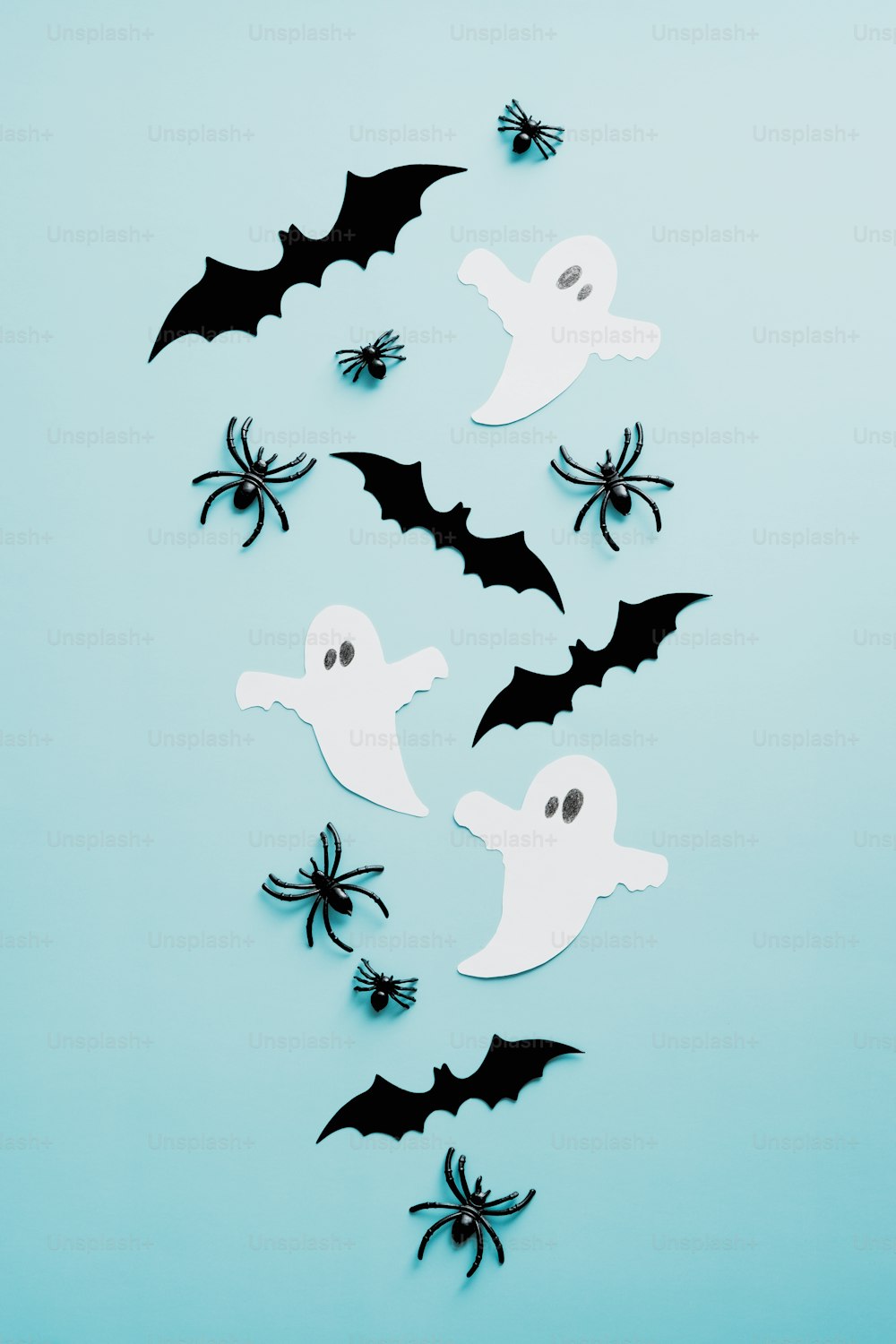Halloween flache Laienkomposition mit Geistern, Spinnen, Fledermäusen auf blauem Hintergrund. Flache Verlegung, Draufsicht, Overhead.