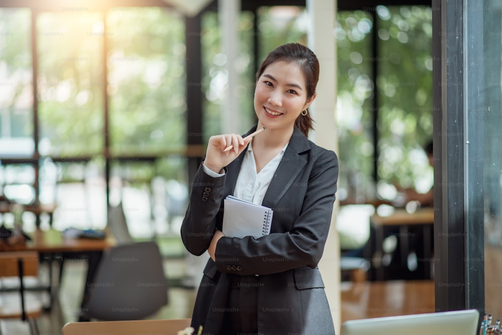 Portrait of young asian businesswoman standing at her office looking at camera.