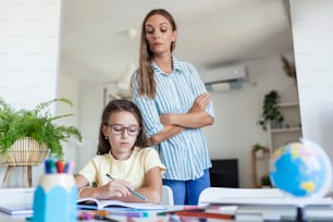 Child having problem with concentration while doing homework. Stressed Mother and daughter Frustrated Over Failure Homework, School Problems. Mother help her her daughter with difficul homework