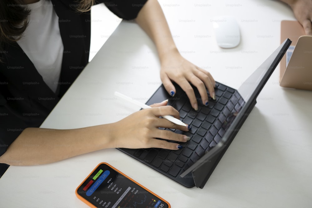 Mujer de negocios recortada que trabaja en línea con una tableta de computadora.