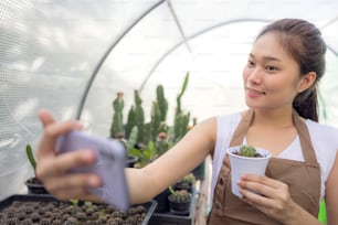 Asia woman enjoys gardening with cactus and is the proprietor of a start-up company that sells trees online.