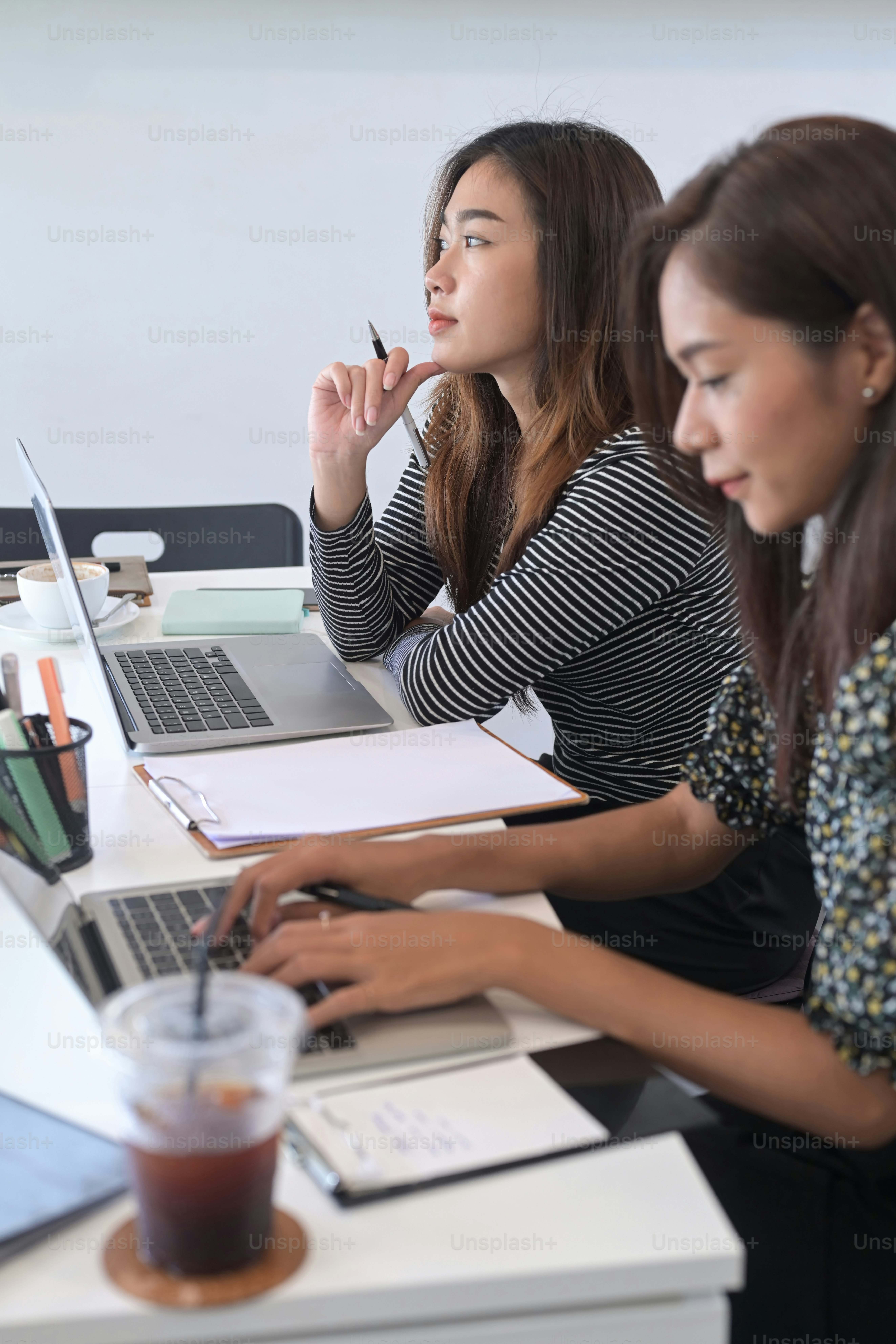 Deux collègues femmes d’affaires travaillant ensemble avec une tablette ...