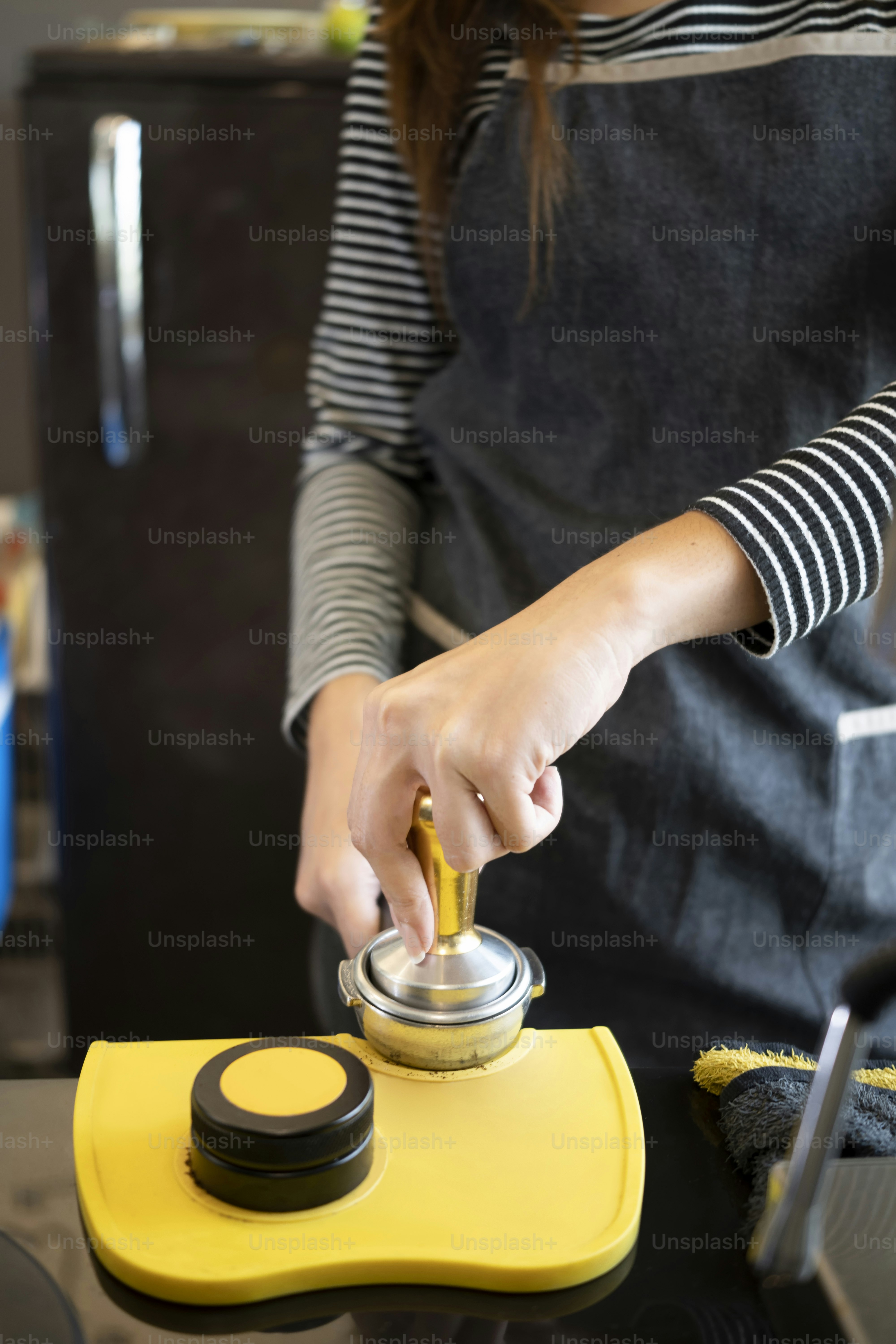 Cropped shot barista preparing coffee while at the bar in coffee shop.