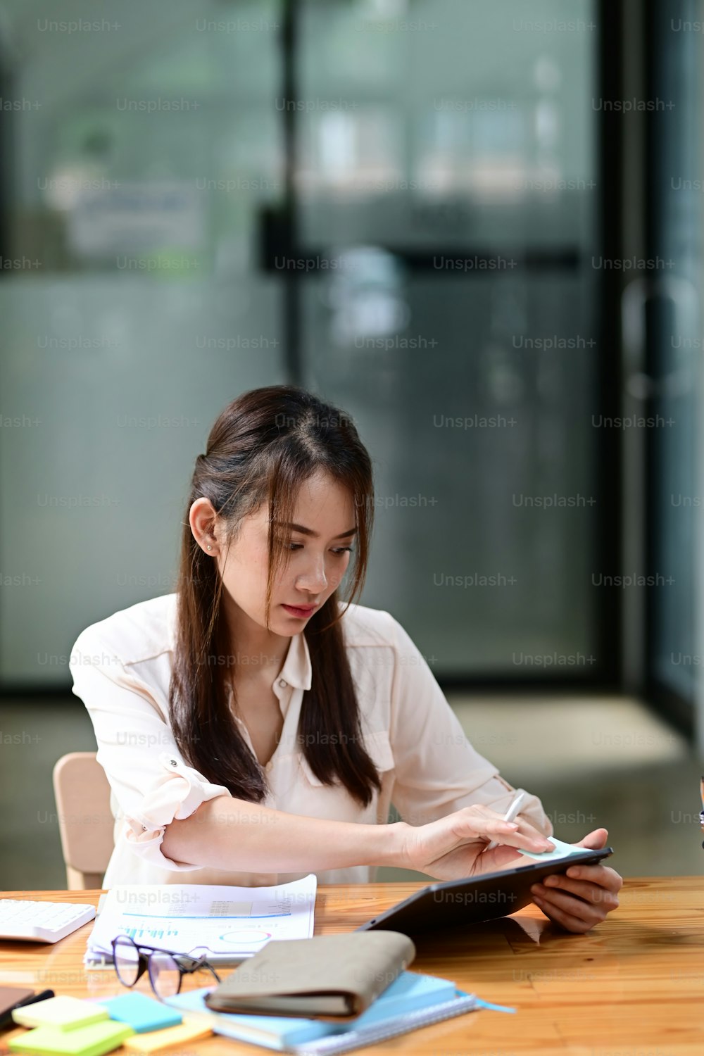 Young female accountant working with digital tablet at office.