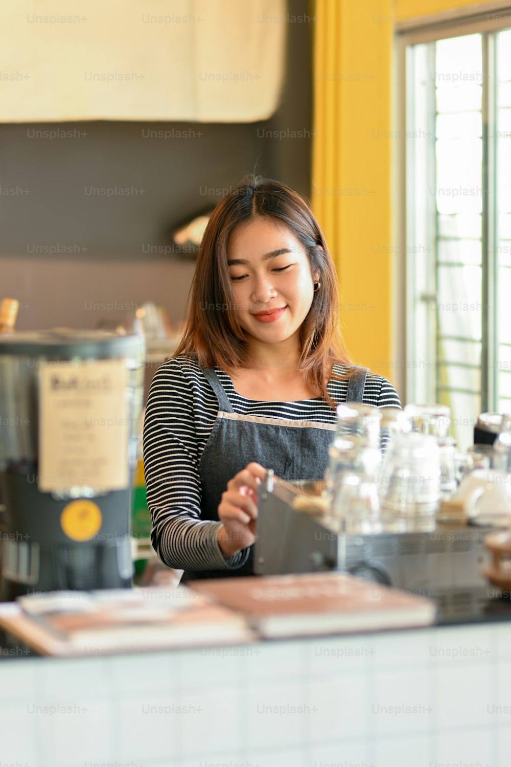 Portrait of Charming asian female barista making coffee with coffee machine at coffee shop, coffee brewing