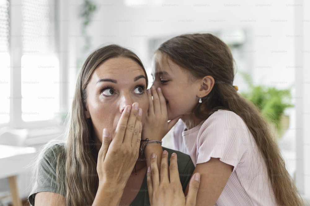 Imagen de cerca madre asombrada escucha noticias increíbles de la hija pequeña, la niña comparte el secreto que cuenta algo interesante mientras la mamá abre la boca se siente sorprendida, confianza, persona confidente, concepto divertido