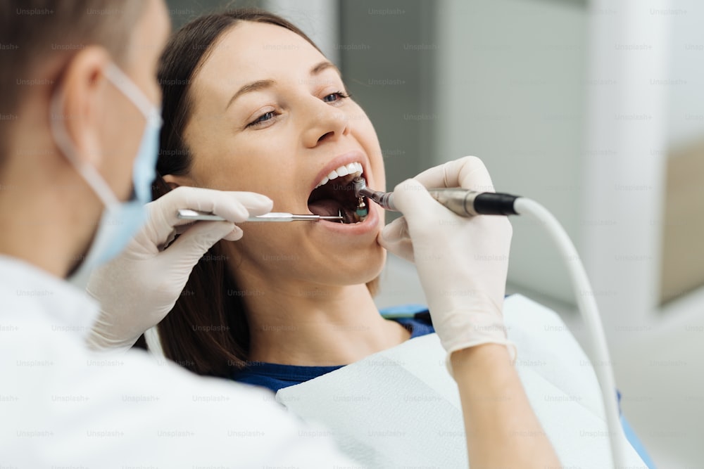 Visión general de la prevención de la caries dental. Niña en la silla del dentista durante un procedimiento de raspado dental. Sonrisa sana.