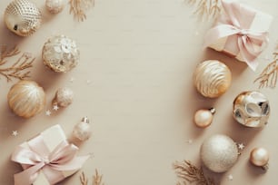Marco navideño hecho de bolas doradas, ramas decorativas, cajas de regalo sobre fondo beige. Plano, vista superior. Maqueta de banner de Navidad con espacio de copia