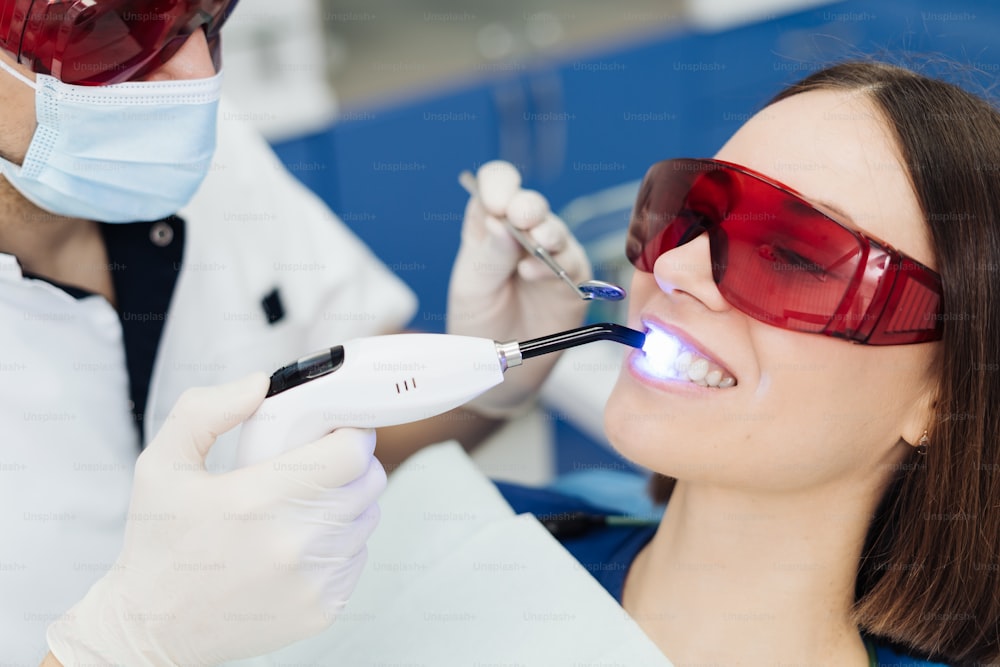 Retrato em close-up de uma paciente do sexo feminino visitando dentista para clareamento dos dentes na clínica