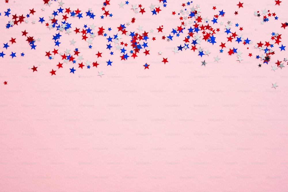 Feliz conceito do Dia dos Veteranos. Estrelas de confete de cores dos EUA no fundo rosa com espaço de cópia. Modelo de banner da Web para o Dia da Independência dos EUA ou Memorial Day