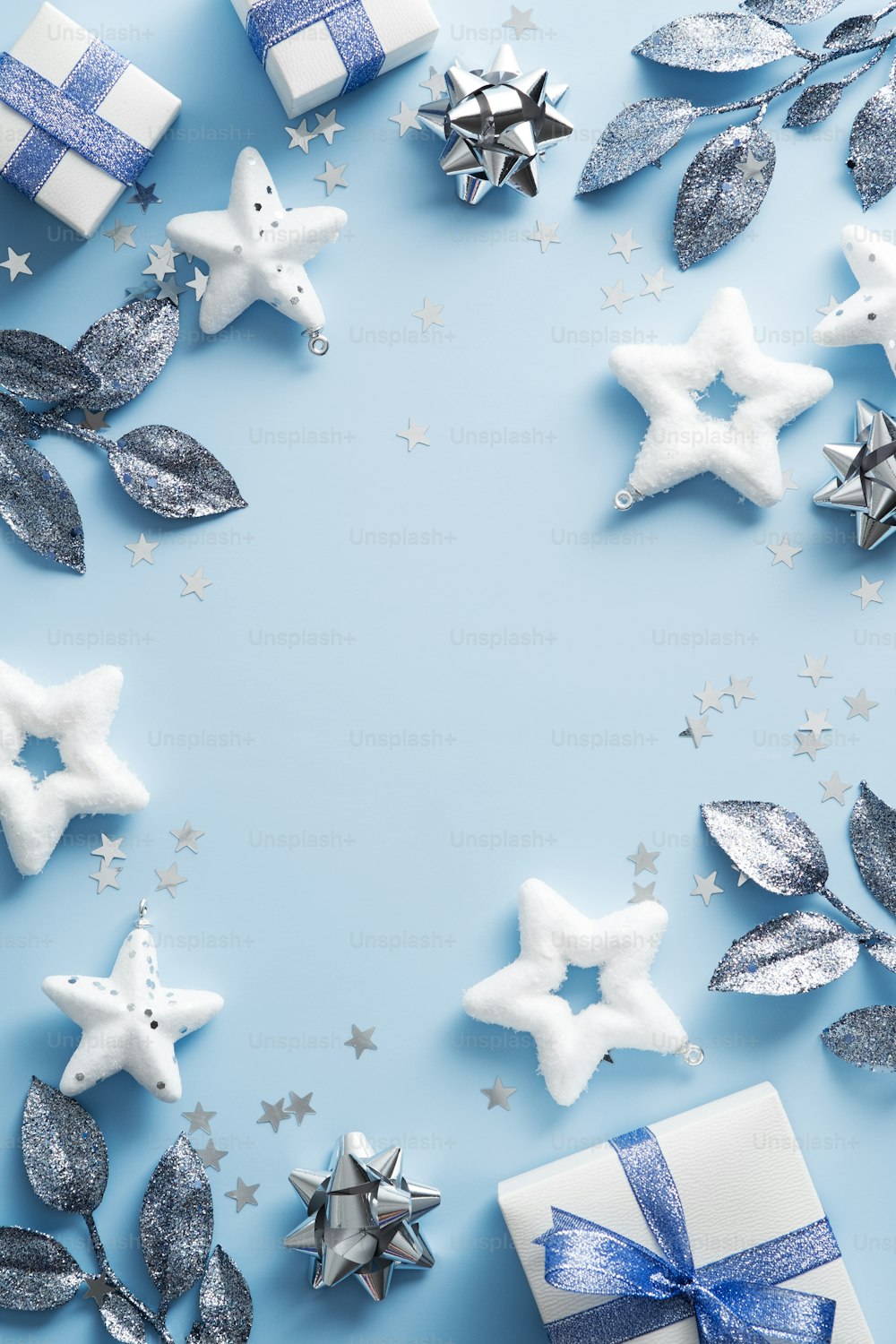 Happy Christmas day background. Elegant Xmas decorations, stars, branches on blue table. New Year vertical banner design, Christmas poster mockup. Flat lay, top view.