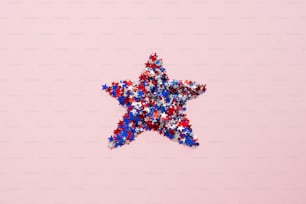 ピンクの背景にアメリカ国旗の紙吹雪の星。フラットレイ、上面図。アメリカ独立記念日、退役軍人の日、労働者の日のお祝いのコンセプト。