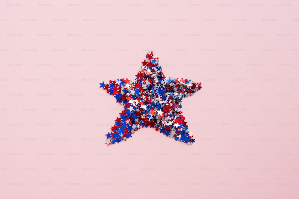 Estrella de confeti de la bandera estadounidense sobre fondo rosa. Plano, vista superior. Día de la Independencia de EE. UU., Día de los Veteranos, concepto de celebración del Día del Trabajo.