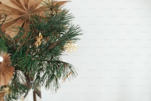Elegantes ornamentos de palha da estrela do Natal em ramos de pinheiro no vaso no fundo da estrela sueca na sala escandinava decorada festiva. Decorações sem plástico ecológico. Espaço para texto