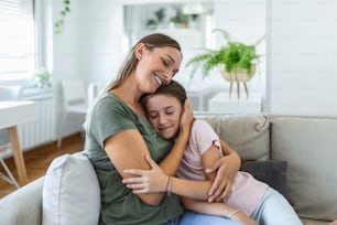 I love you so much. Portrait of happy young mother piggybacking cute smiling little daughter in living room, affectionate school age girl embracing beloved millennial female nanny or foster mom
