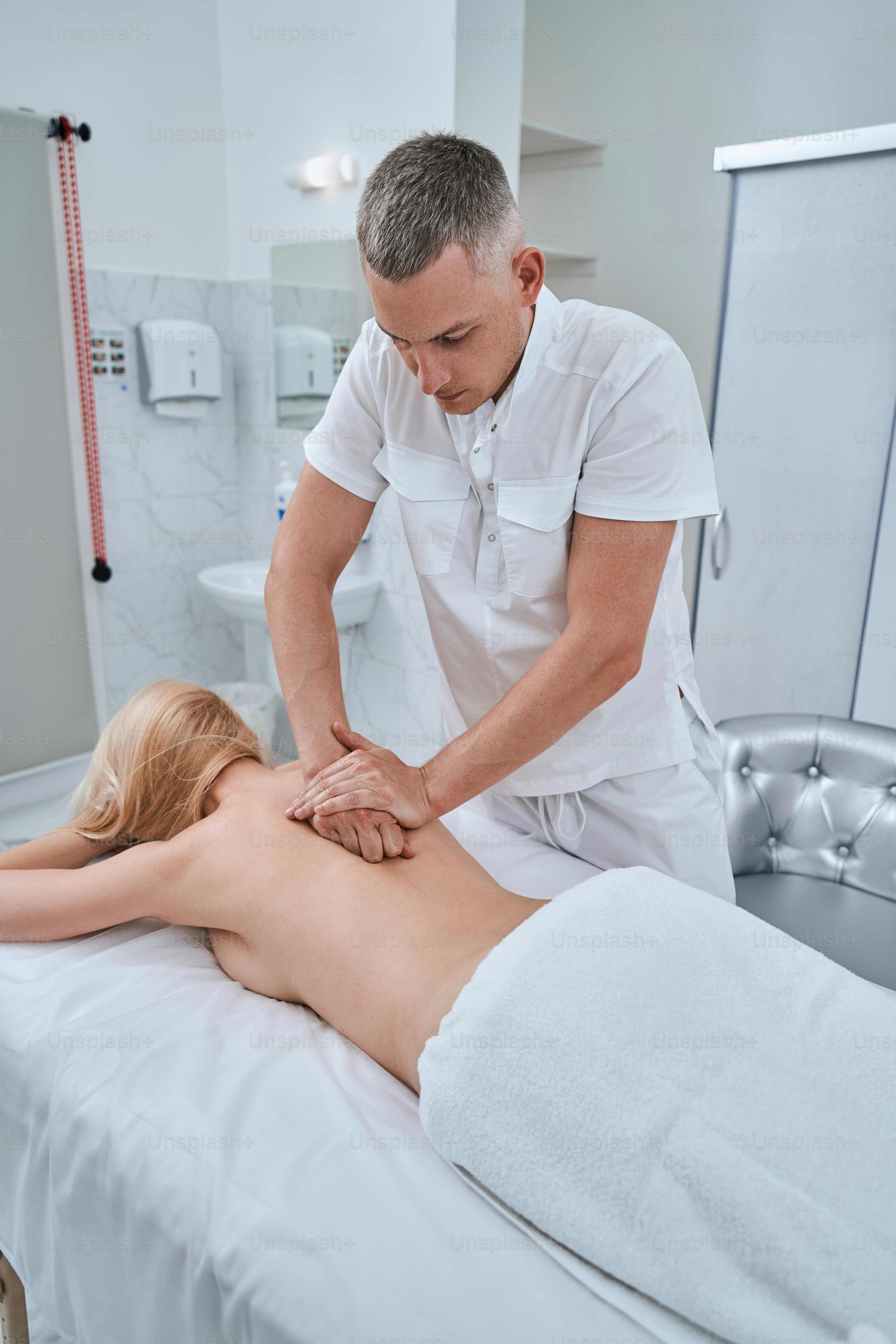 A chiropractor performing a spinal adjustment on a patient