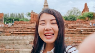 Close-up jovem mochileiro asiático blogueiro mulher casual olhar câmera chamada de vídeo no smartphone compartilhar ao vivo on-line para o público viajar juntos no pagode cidade velha, conceito de férias de viagem turística de estilo de vida.