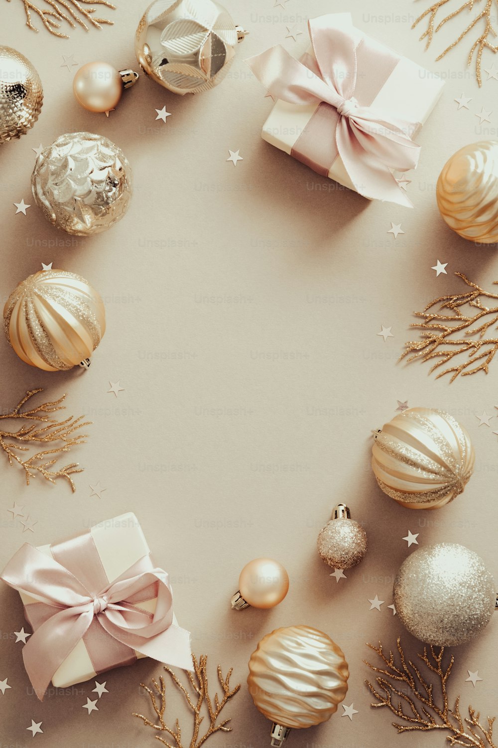 Composizione natalizia. Cornice realizzata con palline dorate e scatole regalo su fondo beige pastello. Posa piatta, vista dall'alto.