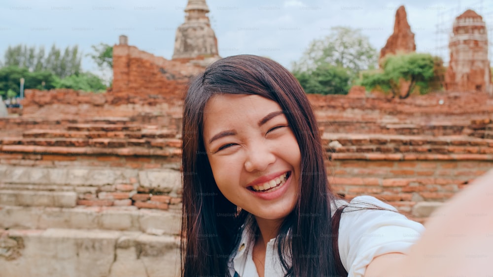Close-up Young Asian backpacker blogger woman casual look camera video call on smartphone share live online for audience travel together at pagoda old city, Lifestyle tourist travel holiday concept.