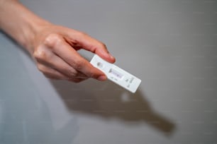 自宅でのセルフテストCOVID-19流行に迅速抗原検査キットを使用しているアジア人女性。テストストリップでCOVID-19の陰性結果を示す成人女性。COVID-19コロナウイルスパンデミック保護コンセプト。
