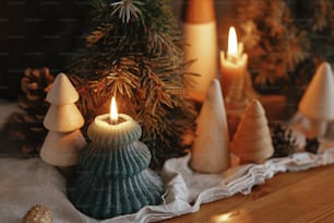 Avvento di Natale. Eleganti candele di Natale accese, pini e pigne decorazioni moderne su sfondo rustico in legno vecchio in sala scandinava serale. Momento atmosferico