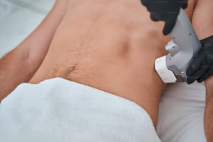 Cropped photo of a spa client during the high-intensity focused ultrasound procedure carried out by a cosmetologist