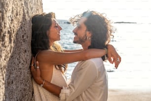 Hermosa pareja romántica en una cita en la playa. Retrato al aire libre de una hermosa mujer joven y un hombre en la luna de miel.