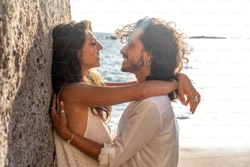 Romantic beautiful couple on a date on the beach. Outdoor portrait of beautiful young woman and man on the honeymoon.