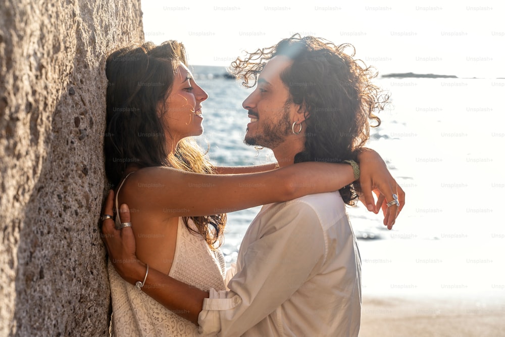 Casal bonito romântico em um encontro na praia. Retrato ao ar livre da bela mulher jovem e homem na lua de mel.
