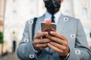 Close up shot of businessman's hand holding smart phone. Communication technology concept during virus pandemic.