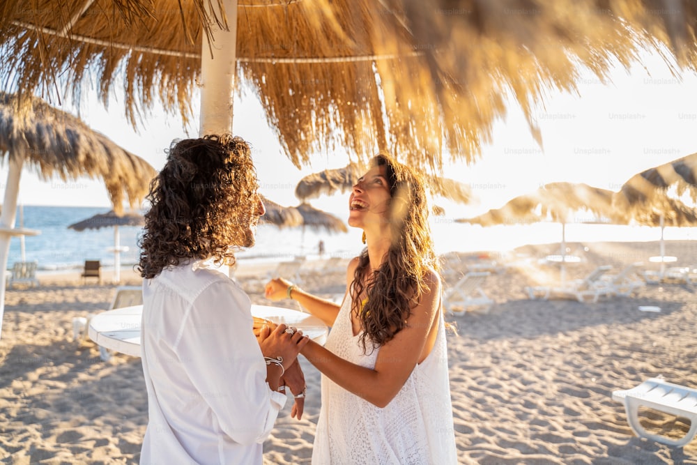 Feliz casal latino bonito passando o tempo juntos na praia tropical. Boho casamento. Emoções de pessoas reais. Amor. Horário de verão.