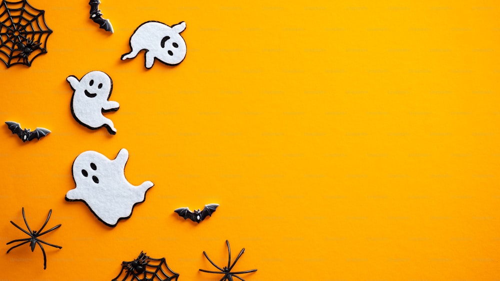 Halloween Hintergrund mit Geistern, Fledermäusen, Spinnen, Dekorationen. Halloween-Party-Einladungskarten-Mockup. Flaches Lay, Draufsicht, Kopierraum.