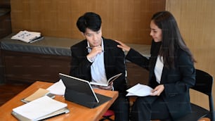 Handicapped worker in a wheelchair working with colleague in office.