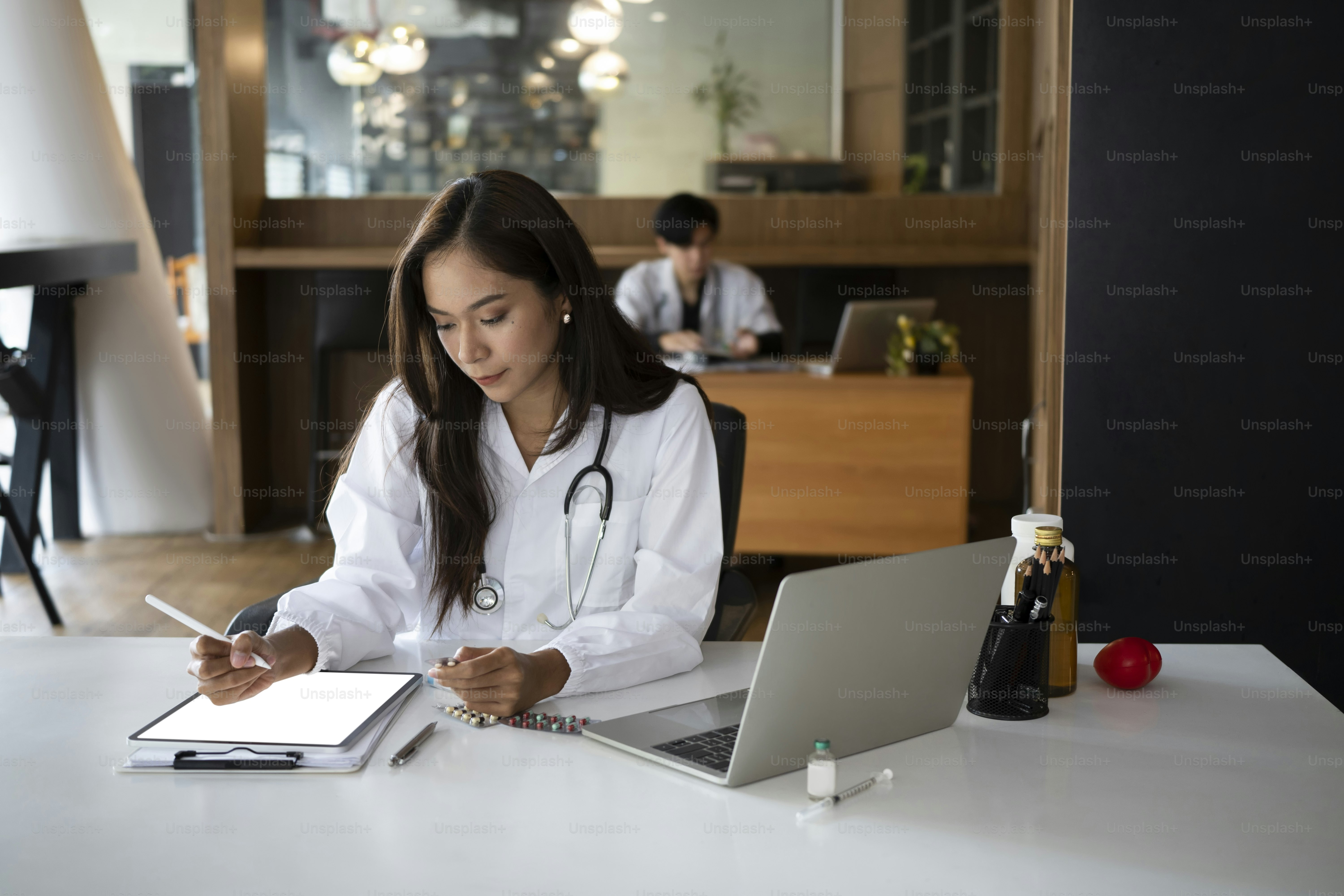 Woman doctor reading medical report on digital tablet at clinic.