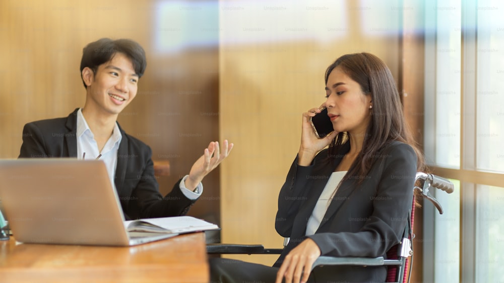 Team office business officer working together, business female talking on phone with business clients while businessman sit beside her in office