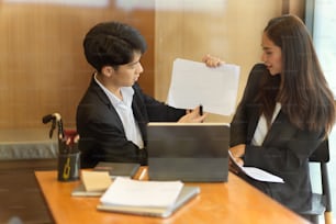 Disabled businessman presenting his work in online meeting via digital tablet with his female partner in office. man in wheelchair