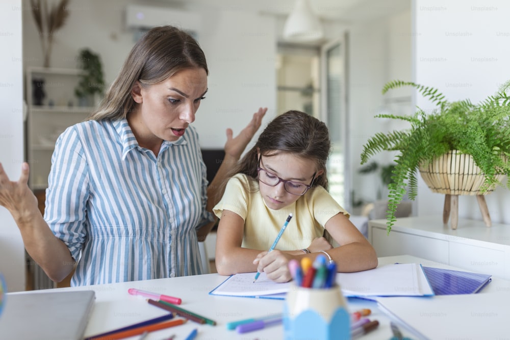 Mother Becoming Frustrated With daughter Whilst Doing Homework. Mom makes the best teacher ever. Mother scolds a child for poor schooling and homework at home